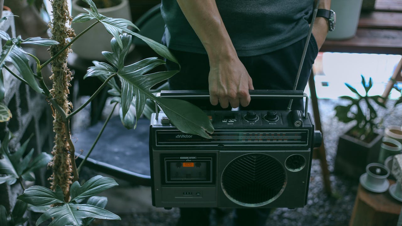 Crafting Captivating Headlines: Your awesome post title goes here A person holding a vintage radio surrounded by tropical plants in Ho Chi Minh City.